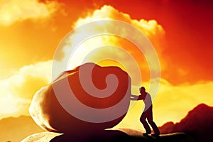 Man pushing a giant, heavy rock over the mountain.