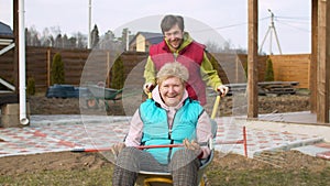 Man pushing his mom in a wheelbarrow