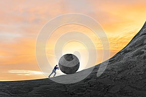 Man pushing large stone to the top