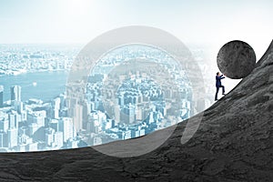 Man pushing large stone to the top