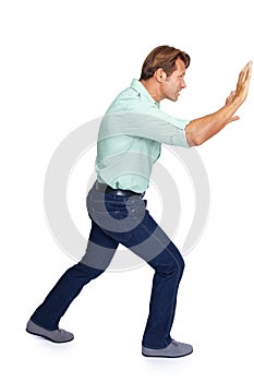 Man, pushing and obstacle or frame in struggle against a white studio background. Isolated casual male walking to push