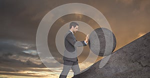 Man pushing rolling round rock