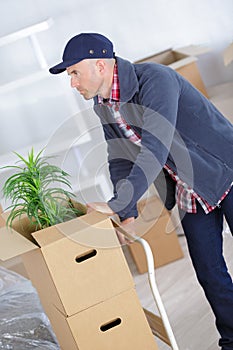 Man pushing stack moving boxes on hand truck