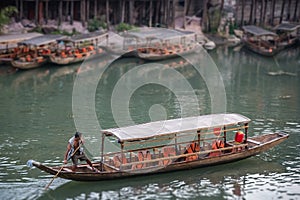 Man pushing and steering old wooden boat