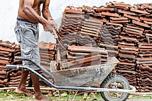 A man is pushing a wheelbarrow full of bricks