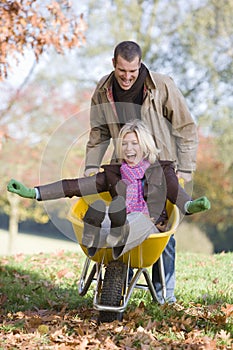 Man pushing wife in wheelbarrow