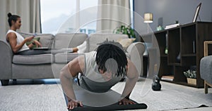 Man, pushups and home for workout training exercise or woman on couch for relax, social media or texting. Male person
