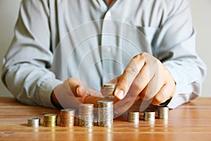 Man put coins on group of coin stack , man plan saving money concept