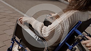 Man put his hand on hand of disabled woman on wheelchair, close up faceless shot. Concept of paralysis, disability, help