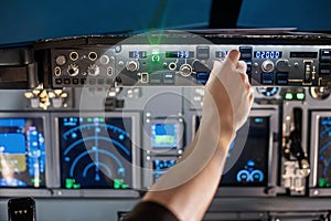 Man put his hand operate switch on airplane panel