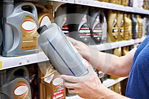 Man with motor oil in shopping cart in store