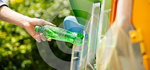 Man put plastic bottle into recycle bin in park.