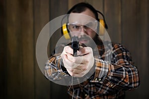 Man with put on protective goggles and ear training in pistol sh