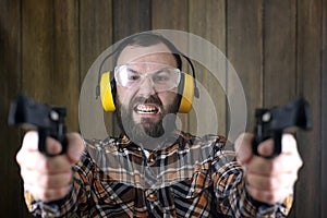 Man with put on protective goggles and ear training in pistol sh