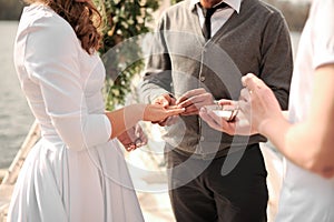 Man puting the ring on his bride on the wedding ceremony