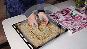 A man puts a baking sheet with baked multi-cereal loaves on the table. The camera moves on a slider