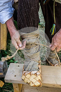 A man puts on a bast shoe