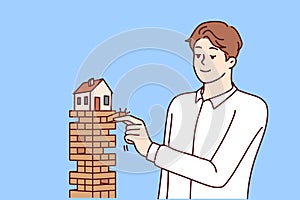 Man puts house in danger by pulling blocks from under building for concept of risky mortgage loan