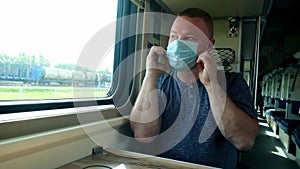 Man puts on a medical mask on the train