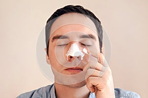 Man puts on and removes a strip for the nose from black dots. Coal cleaning strips from blackheads and comedones. concept of