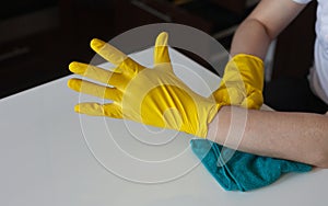 Man puts on rubber gloves to clean up the kitchen. Cleaning service and disinfection