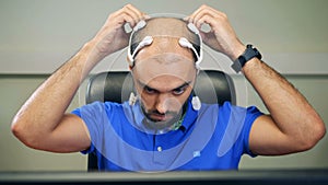 A man puts on sensors on a head, close up.