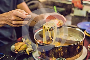 The man puts the soup in a plate photo