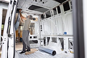 Man puts thermal insulation on the inside of a van