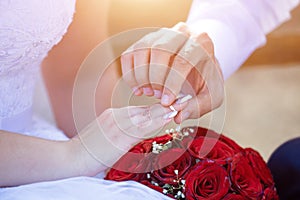 A man puts a wedding ring on woman& x27;s hand. Wedding list of the bride and groom.