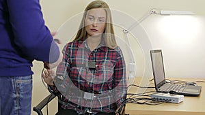 A man puts a woman on the sensors lie detector test