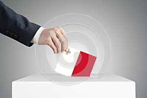 Man putting a ballot into a voting box