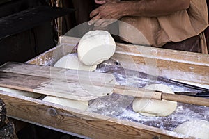 Man putting bread dough in the wood oven