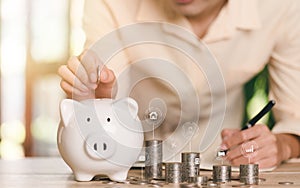 man putting coin money in piggy bank,concept of a loan for housing,saving money for the future,credit for purchase of real estate,