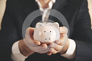 Man putting coin in piggy bank. saving money, finance concept.