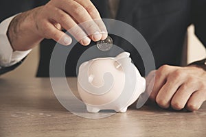 Man putting coin in piggy bank. saving money, finance concept.