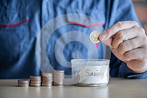 Man putting coins into money box with savings and analysis business investment strategy with income of money coin for future