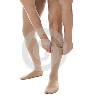 Man putting on compression stocking against background, closeup