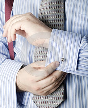 Man putting on cufflinks