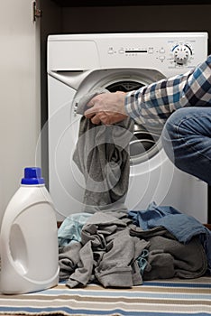 Man putting dirty clothes into washing machine