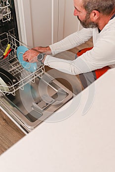 man putting dishes in the dishwasher