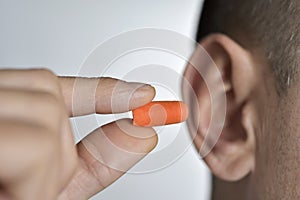 Man putting on an earplug