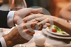 Man Putting Engagement Ring On Girfriend`s Finger After Proposal In Restaurant