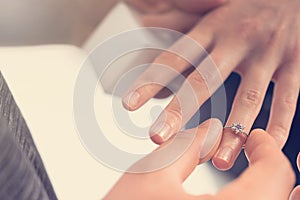 Man putting engagement ring on woman hand
