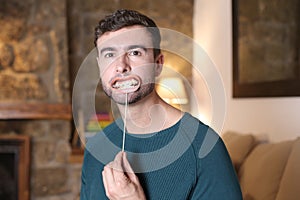 Man putting on a fake smile with metallic brackets