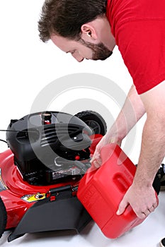 Man Putting Gas Into Lawn Mower Over White