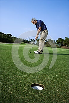 Man putting at golf course.