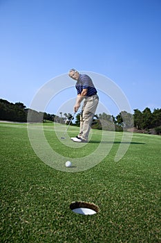 Man putting at golf course.