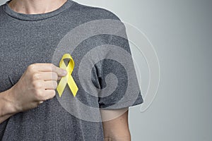 Man putting green ribbon on his shirt. Awareness symbol