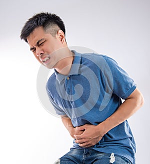 Man putting his hands for belly or stomach ache on white background