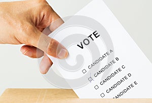 Man putting his vote into ballot box on election